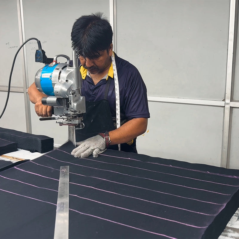 Meet the Hands Behind Your Bag_A look inside our factory in India, from the first cut to the final stitch_Canvas fabric is layered and cut by hand, one panel at a time.
